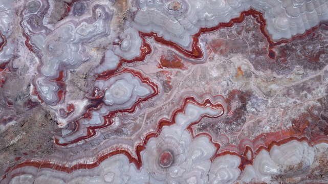 Aerial view of Bentonite Hills, showcasing unique colorful banded clay formations with intricate swirling patterns of red, white, and grey earth in Wayne County, Utah, United States.
