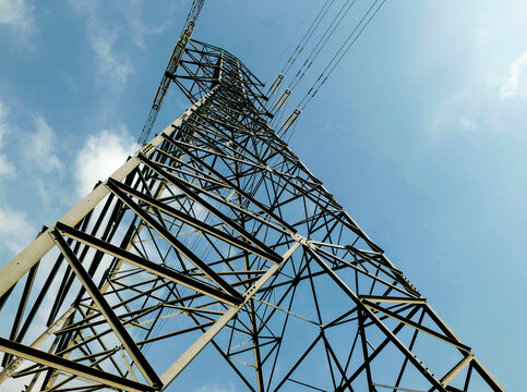 View of a high-voltage electricity transmission tower with steel lattice structure against a clear blue sky in Islamabad, Islamabad Capital Ter, Pakistan.