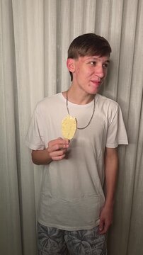garoto adolescente comendo picol&aacute; de chocolate branco 