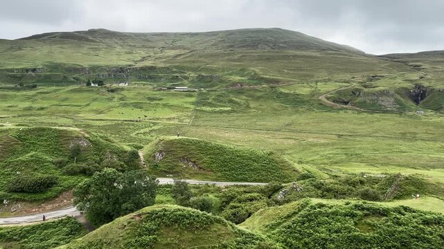The Fairy Glen on the Isle of Skye, unique geological landscape with grassy conical hills, winding road and small pond, magical Scottish nature.