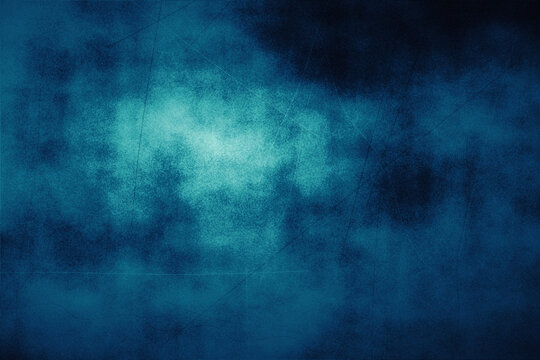 Abstract dark blue grunge texture background with bright central light, perfect for moody graphic designs or atmospheric backdrops.