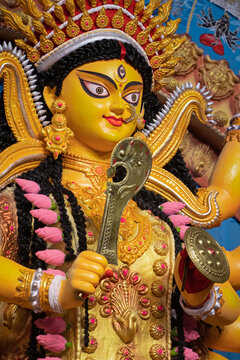 Narayanganj, Dhaka, Bangladesh - 22 October 2020: View of a vibrant and ornate Durga idol decorated with traditional golden jewelry and holding a weapon during the Durga Puja festival.