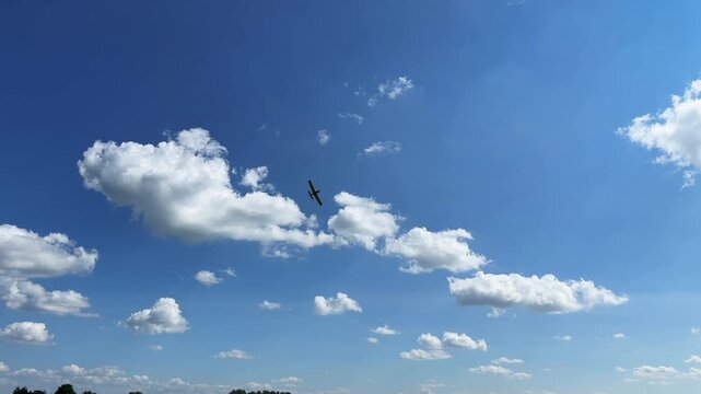 A crop duster plane spraying an agricultural field in the midwest in summer