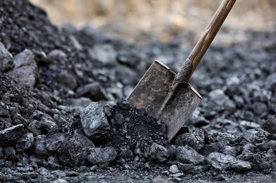 Shovel standing in pile of black coal mining