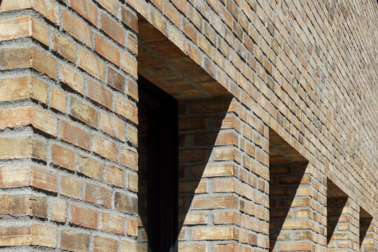 Modern brick building facade creating urban geometric patterns