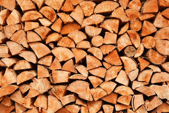 Rustic background of stacked wooden logs. Firewood texture, close up. Renewable energy and heating concept.
Firewood stack texture background. Wood logs pattern.
