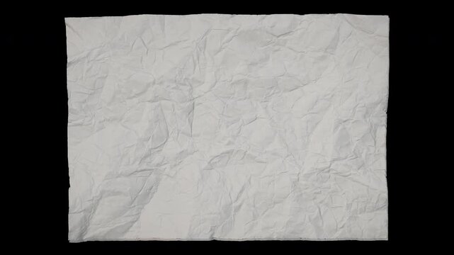Stop motion animation of a white crumpled paper sheet unfolding and flattening out. Smooth paper texture reveal with isolated black background, perfect for transitions, title backgrounds, motion desig