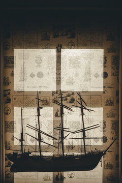 View of a detailed model ship silhouette displayed against a window with a vintage map-patterned curtain in Laane County, Estonia.