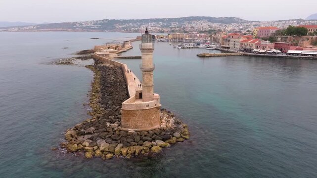  View of Chania with the amazing lighthouse, mosque, venetian shipyards, Crete, Greece.Waves crashing on lighthouse, Beautiful Greece and best scenic places - panorama