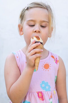 Little Girl Holding Ice Cream Cone and Looking at Camera
