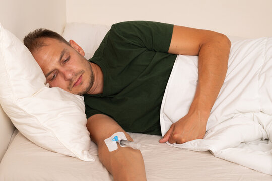 Sick Man Receiving Oxygen and Intravenous Therapy While Lying in Bed