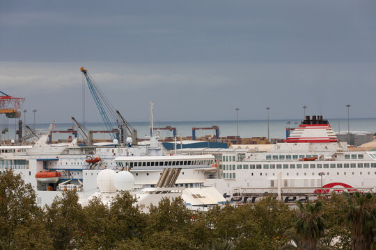 Passenger Ships Docked at Industrial Seaport Under Stormy Sky