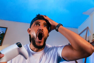 Male gamer reacting with surprise during video game © Djavan Rodriguez
