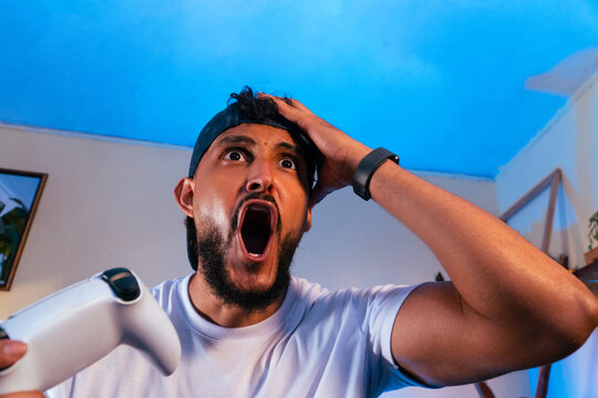 Male gamer reacting with surprise during video game
