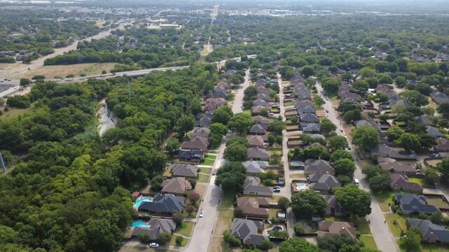 Linear residential streets flank Ten Mile Creek corridor throughout southern DFW metroplex. Brick homes, swimming pools, verdant forest buffers illustrate peaceful suburban community, DeSoto, TX