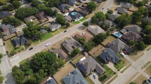 Mesa Verde neighborhood streetscapes wind beside Pleasant Run Road across southern Dallas suburbs. Rooftop photovoltaic panels, private swimming pools highlight suburban residences, DeSoto, TX