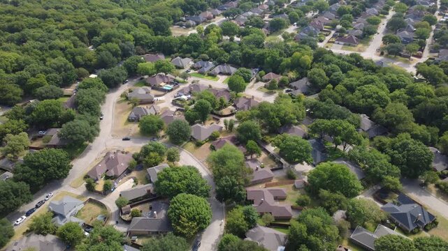 Mesa Verde subdivision streetscapes weave through dense mature woodland within southern DFW suburbs. Single-family homes, leafy cul-de-sacs display established suburban planning, DeSoto, Texas