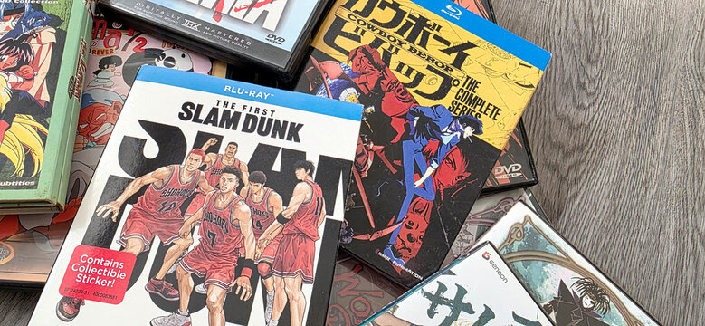 scattered pile of anime blu ray dvds on a wood surface, including slam dunk and cowboy bebop, August 25, 2026 Schaumburg, IL