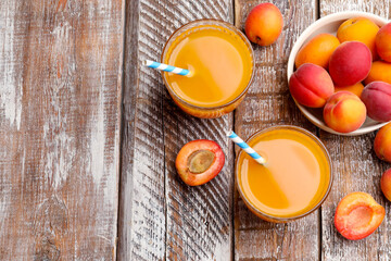 Apricot juice in glasses and fresh fruits on wooden table, flat lay. Space for text © New Africa