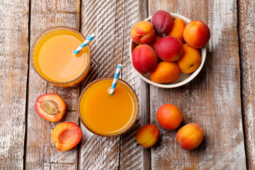 Apricot juice in glasses and fresh fruits on wooden table, flat lay © New Africa