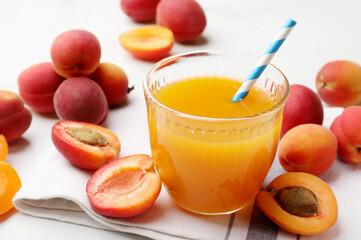 Apricot juice in glass and fresh fruits on white table, closeup © New Africa