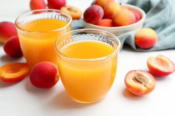 Apricot juice in glasses and fresh fruits on white table, closeup © New Africa