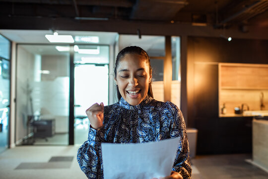 Happy businesswoman celebrating good news in modern office