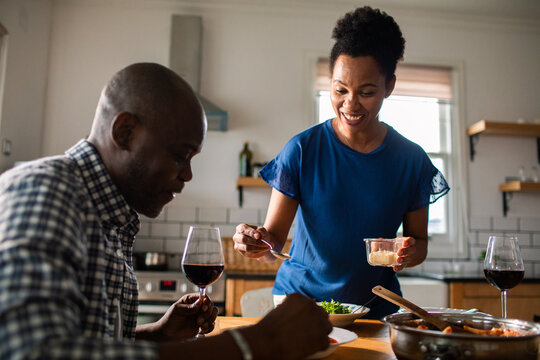 Mature couple cooking and dining together at home kitchen