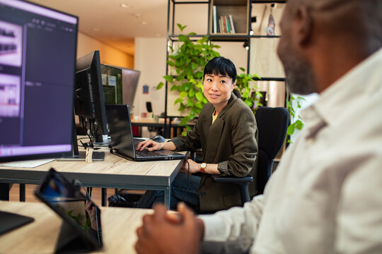 Two coworkers collaborating at modern office desk