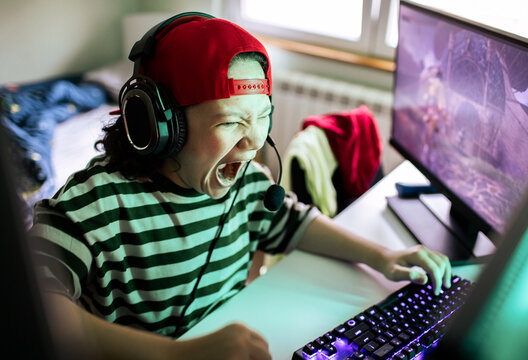 Child wearing headset yelling while gaming on pc at home