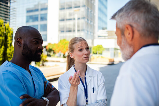 Doctors and nurses discussing patient care outside hospital