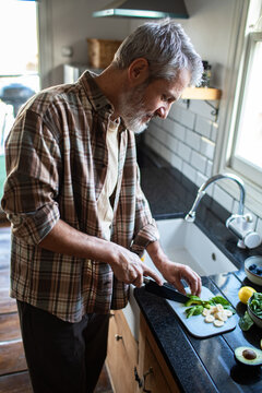 Senior man preparing healthy ingredients in home kitchen