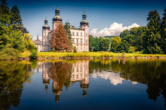 Vrchlabsky castle reflected in the calm waters of old pond. Sunny summer cityscape of Vrchlabi town, Trutnov District, Hradec Kralove Region of Czech Republic, Europe. Traveling concept background.