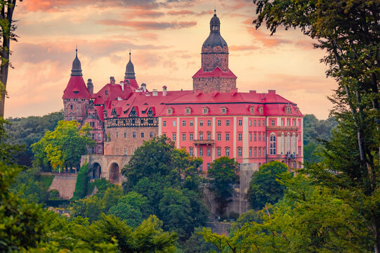 Colorful evening view of Ksiaz castle. Stunning summer sunset in green forest with beautiful palace, Piastow Slaskich, Walbrzych, Poland, Europe. Traveling concept background.