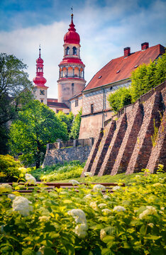 Bright morning view of Nachod castle with blooming white flowers. Breathtaking summer cityscape of Nachod town, Hradec Kralove Region, Czech Republic, Europe. Traveling concept background.