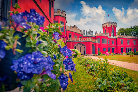 Colorful morning view of Hradek u Nechanic red Tudor Romantic chateau with blooming violet flowers. Exciting summer cityscape of Hradek village, Czech Republic, Europe. Traveling concept background.