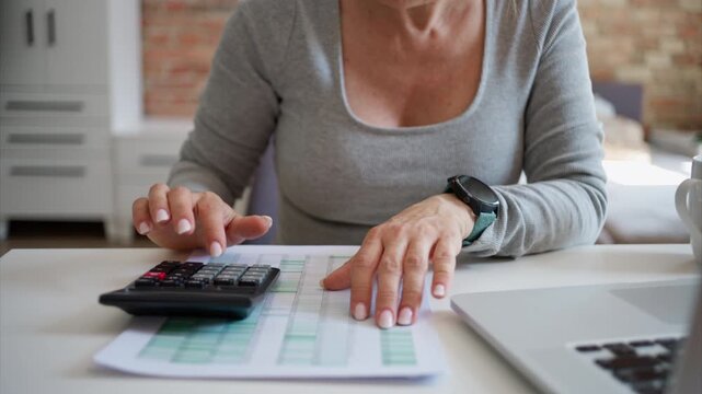 Woman Manages The Family Budget At Home In Close-Up