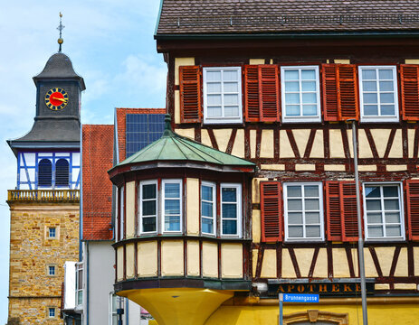 Historisches Fachwerkhaus mit Erker und Blick auf den markanten Stadtturm in Neuenstadt am Kocher, Baden-W&uuml;rttemberg, Deutschland