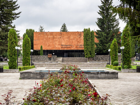 Stepanavan, Armenia - July 18, 2026: flowerbed and edifice of Stepan Shaumian House Museum on central square in Stepanavan city in Lori Province of Armenia on overcast summer day