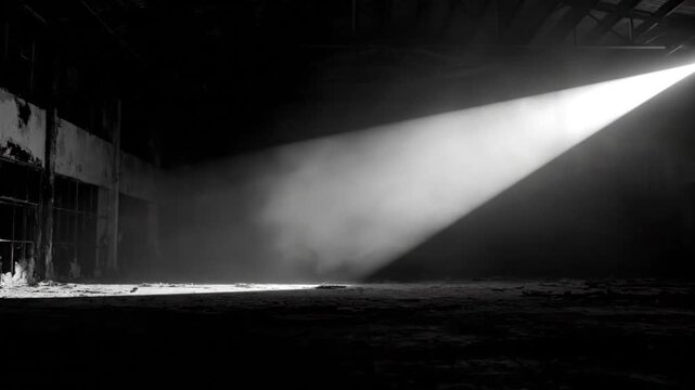 Dramatic beam of light illuminating a dark, abandoned industrial space with an evocative ambiance