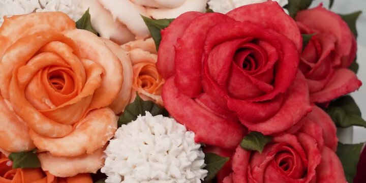 A stunning, high-definition macro shot showcasing an elegant bouquet crafted from edible cupcakes. The detailed composition features realistic buttercream icing piped into vibrant orange roses, rich r