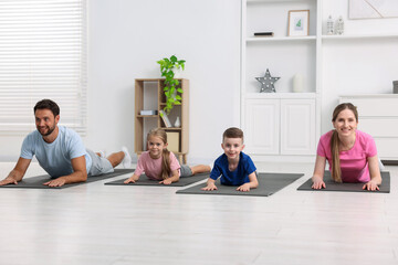 Fototapeta premium Happy family doing exercise together at home
