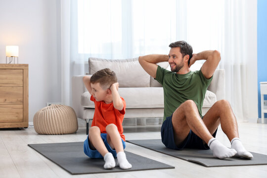 Father and his son doing exercise together at home
