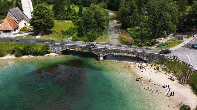 Flight over the stone bridge and beach at Lake Bohinj, Slovenia