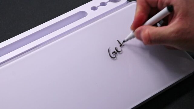 European male hand writing get well on whiteboard with black pen and erases it with white sponge afterwards for seamless looping message writing on whiteboard. Speedy recovery wishes