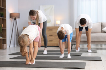 Fototapeta premium Parents and their kids doing exercise together at home, selective focus
