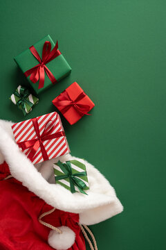 Merry Christmas and Happy New Year with Santa Claus present in a red velvet sack on vertical green table