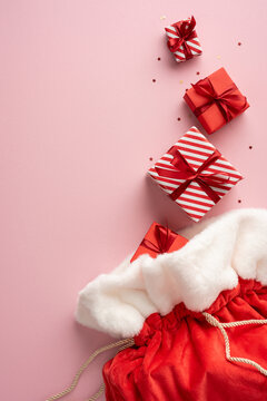 Merry Christmas and happy New Year red Santa presents with ribbons and festive confetti on pink vertical background