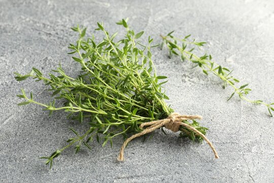 Bunch of fresh thyme on grey table, closeup