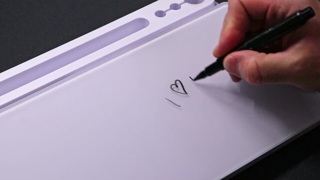 European male hand writing i love you on whiteboard with black pen and erases it with white sponge afterwards for seamless looping message writing on whiteboard. I love you with heart text message.